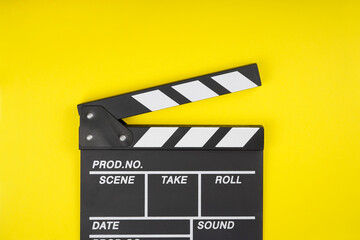 Fototapeta na wymiar Clapperboard on yellow background. Movie, filmmaking, cinema concept. Top view, flat lay, copy space