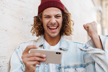 Curly man playing games by mobile phone