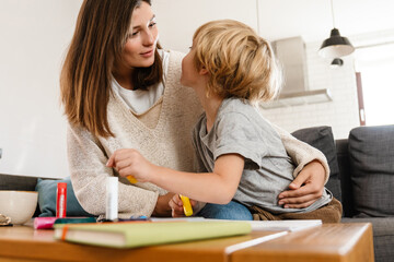 Fototapeta premium Beautiful woman drawing at home with her son