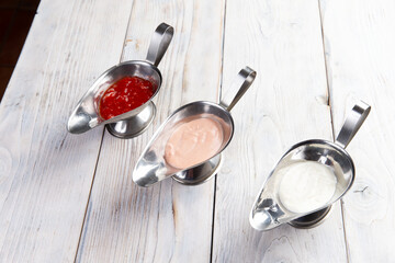 Three different sauces. on a light wood background.