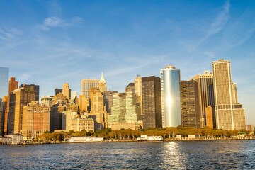 Fototapeta na wymiar Amazing sunset colors of Lower Manhattan skyline from the ferry boat, New York City