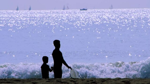海でサーフィンをする親子