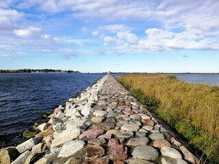 Beautiful view of the stone pathway leading to a lake in Wyspa Sobieszewska, Poland © Marianna Jaszczuk/Wirestock