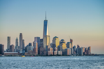 Naklejka premium Amazing sunset colors of Lower Manhattan skyline from the ferry boat, New York City