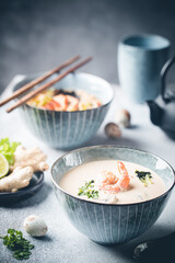 Fototapeta na wymiar Tom Yum Kung soup, a Thai traditional spicy prawn soup in a bowl on gray background