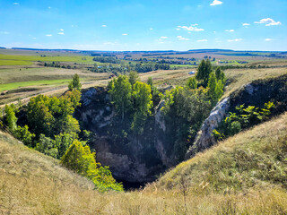 mysterious, unusual cave in a field under the ground. mountain rock walls of the cave, view of the...