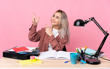 Young student woman working in a table pointing with the index finger a great idea