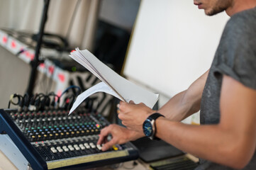 Behind the scene. Sound technician adjusting sound elements for the theatrical performance and...