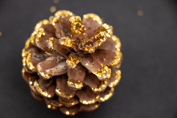Cones covered with sparkles on a black background. Holidays.
