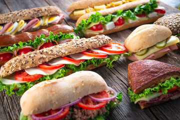 Assorted sandwiches on wooden background.