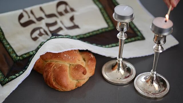 Jewish woman hands lights Sabbath candles on Sabbath eve. 