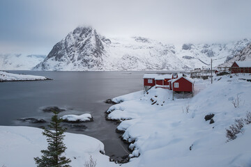 Red cabins of fishermen on the seashore and behind the mountain