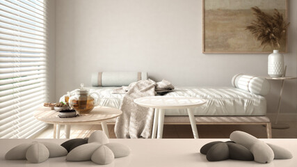 White table, desk or shelf with five soft white pillows in the shape of stars or flowers, over blurred modern living room with sofa and tables, teatime, architecture interior design