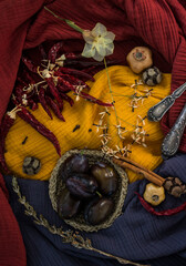 Autumn still life with fresh plums and dried fruits. Fabric texture background. Colors of autumn. 
