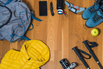 Equipment for hiking on a wooden floor background. Copy space.