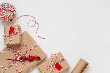 Christmas gifts on the white background with copy space. Top view of twine, craft paper and...