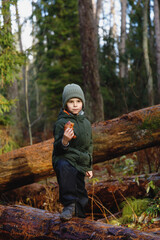 snack on a walk in the woods. little boy with croissant in nature