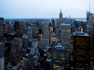 View of New York City from the top at night, Skyscrapers and buildings, afternoon lights, offices lights at the horizon, antennas on the roofs, human structures, city life