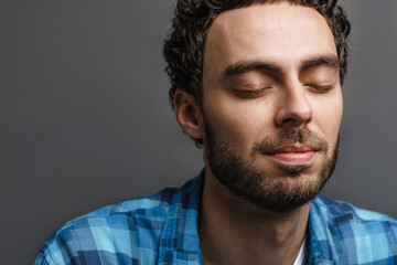 Fototapeta premium Unshaven handsome calm guy posing with eyes closed
