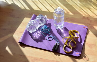 Training at home because of covid, jugs of water, purple mat and yellow rubber