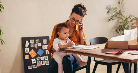 Mother talking on smart phone at home office