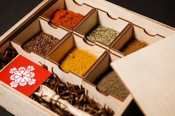 various spices in boxes on a black background