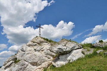 Fototapeta premium Metal cross on top of a rocky mountain