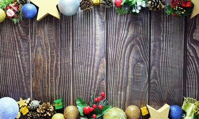 On a rustic wooden table, varied Christmas decorations, with space in the center. Merry Christmas.