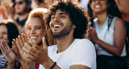 Smiling man watching a soccer match at stadium