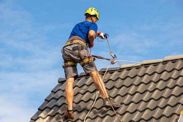  high-altitude worker painting a roof