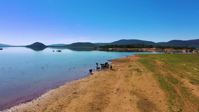 Aerial of a cattle herd drinking water and cooling down at Gaborone dam in Botswana