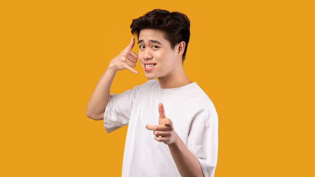 Man pointing index finger on camera, doing phone gesture