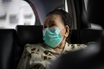 Elder woman using protective face mask during traveling. Coronavirus or COVID-19 pandemic concept....