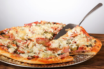 wonderful beautiful and tasty pizza with ham on the table