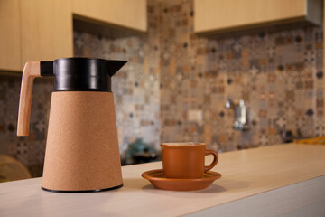 Coffee thermos bottle with cup, placed on the counter of a Brazilian kitchen.
Kitchen as a background. Coffee concept. Brazil concept.