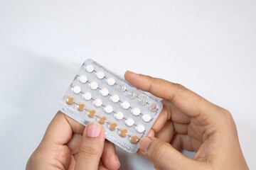 women hand holding birth control pills close up 
