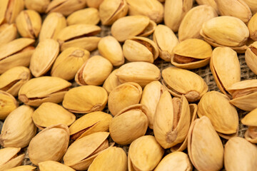 Salted pistachios lie on the burlap. Close up.