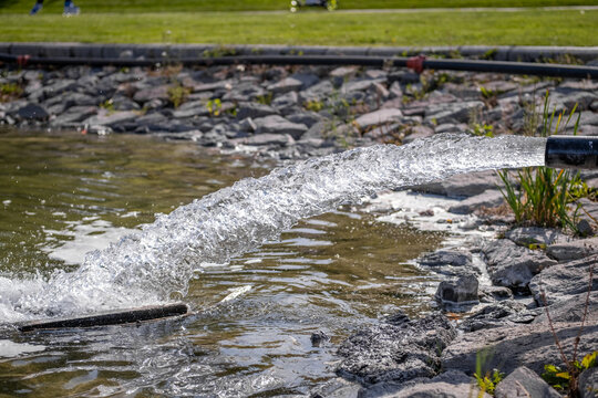 Gushing water filling a pond in a park