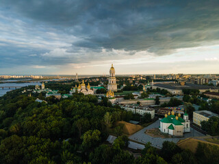 Aerial evening view to the Kyiv Pechersk Lavra monastery. Stormy golden hour - 391253059