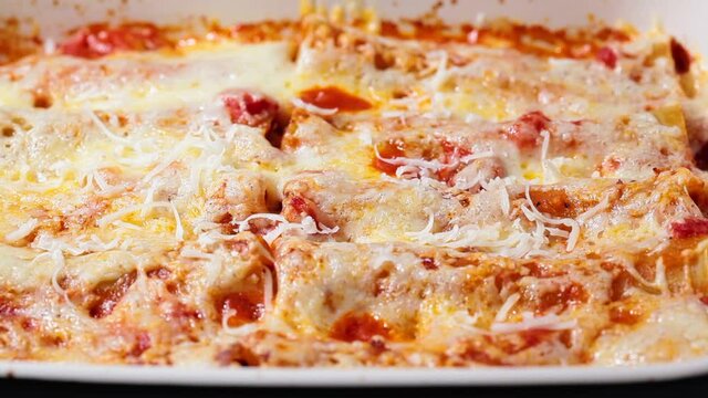Traditional cannelloni with meat, tomato sauce and cheese. Italian cuisine concept.