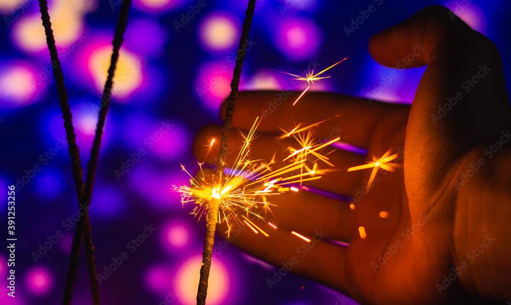 Wall mural Man trying to catch sparks from sparkler beautiful magical photo banner