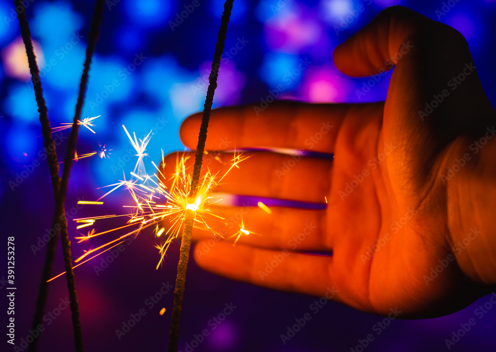 Wall mural Man trying to catch sparks from sparkler beautiful magical