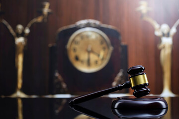 Fototapeta na wymiar Law concept. Judge wooden gavel and old clock on brown background.