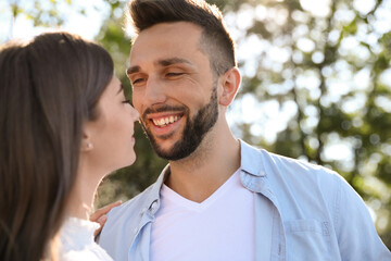 Fototapeta premium Lovely young couple dancing together in park on sunny day