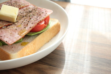 パンとバターとトマトとアボカドをのせた白いお皿