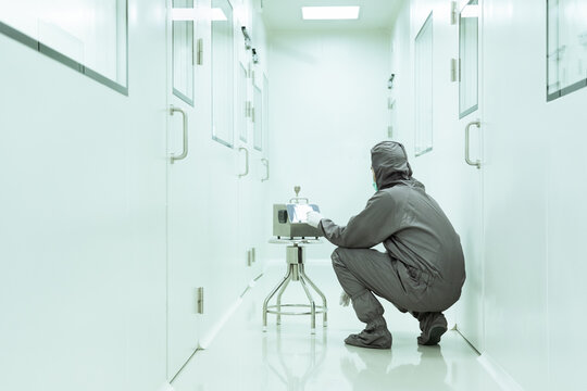 Unidentified operator is setting the instrument for airborne particle counter in the cleanroom, concept of cleanliness, environment and particle contamination in HVAC system.