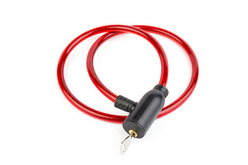 Flexible red bicycle cable with key on white background.  Security and safety concept.