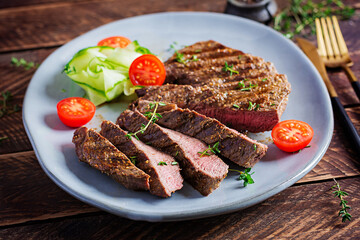 Grilled juicy steak medium rare beef with spices and fresh salad.