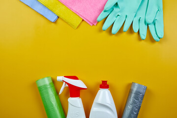 Flat lay of variety house cleaning product on yellow table with copy space