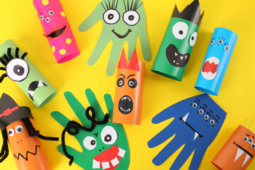 Funny monsters on yellow background, flat lay. Halloween decoration